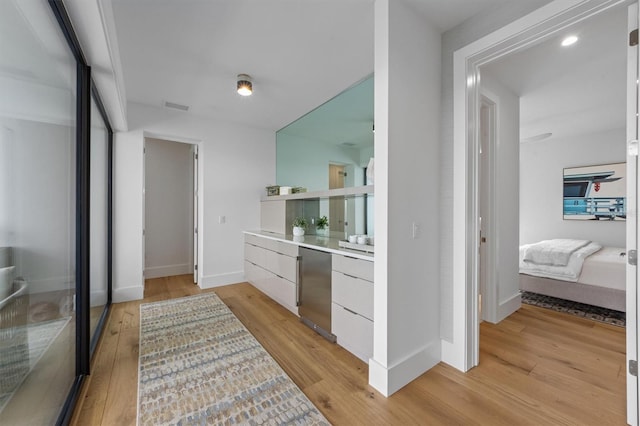 ensuite bathroom with visible vents, ensuite bath, baseboards, and wood finished floors