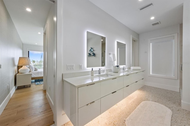 ensuite bathroom with ensuite bath, visible vents, and a sink