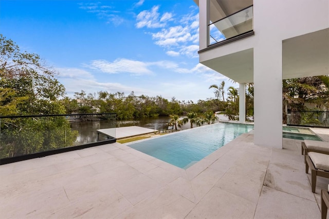 view of swimming pool with an infinity pool, a patio, and a water view