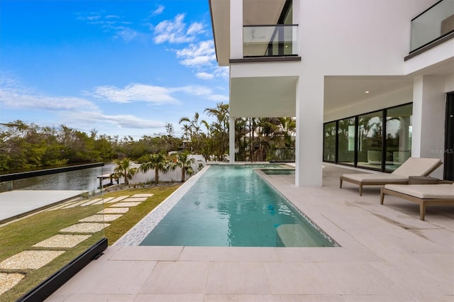 outdoor pool featuring a patio area and a water view