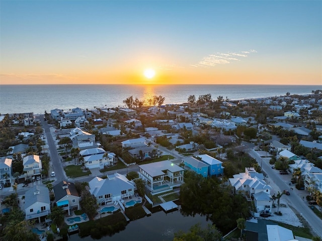 aerial view at dusk with a residential view and a water view