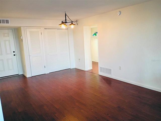 interior space with baseboards, visible vents, and hardwood / wood-style floors