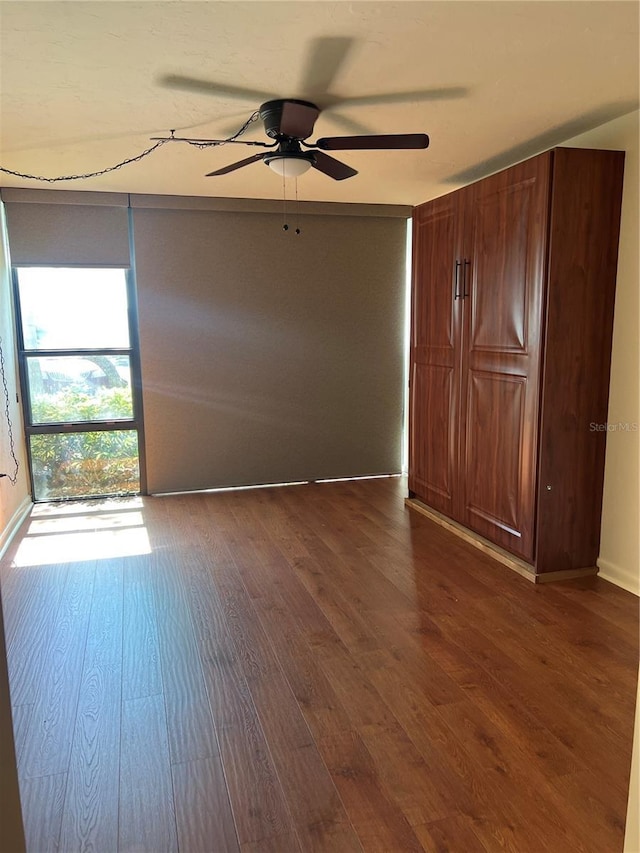 spare room with ceiling fan and dark wood finished floors