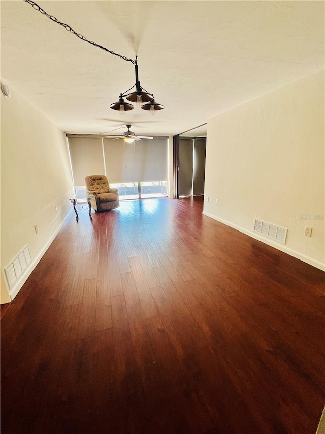 unfurnished room featuring visible vents, ceiling fan, baseboards, and wood finished floors