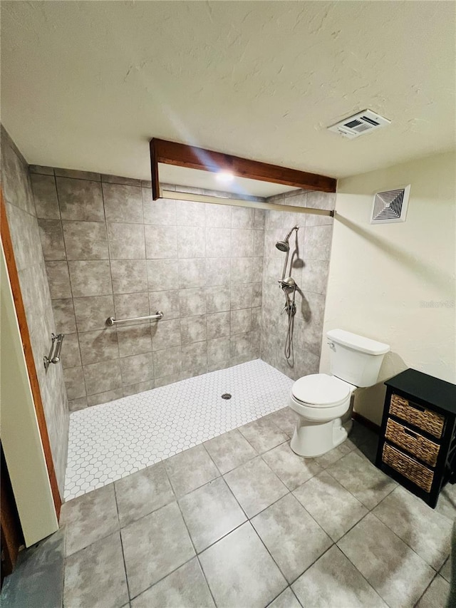 full bath with toilet, a textured ceiling, visible vents, and tiled shower