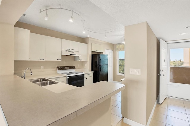 kitchen with electric stove, light tile patterned floors, freestanding refrigerator, a sink, and under cabinet range hood