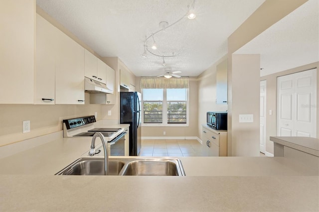 kitchen with a textured ceiling, under cabinet range hood, a sink, light countertops, and black appliances