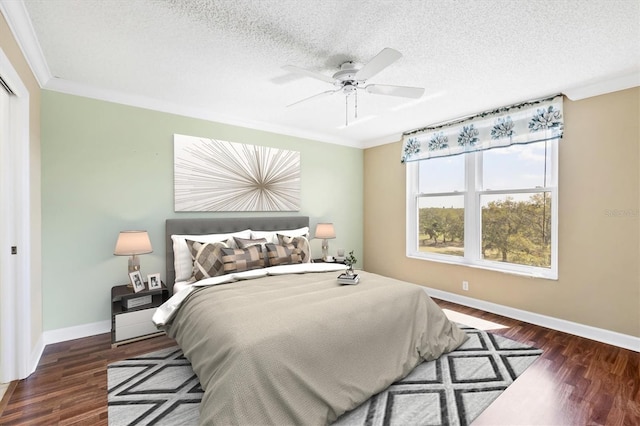 bedroom featuring ornamental molding, ceiling fan, a textured ceiling, wood finished floors, and baseboards