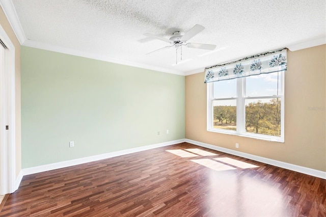 empty room featuring a textured ceiling, baseboards, wood finished floors, and crown molding