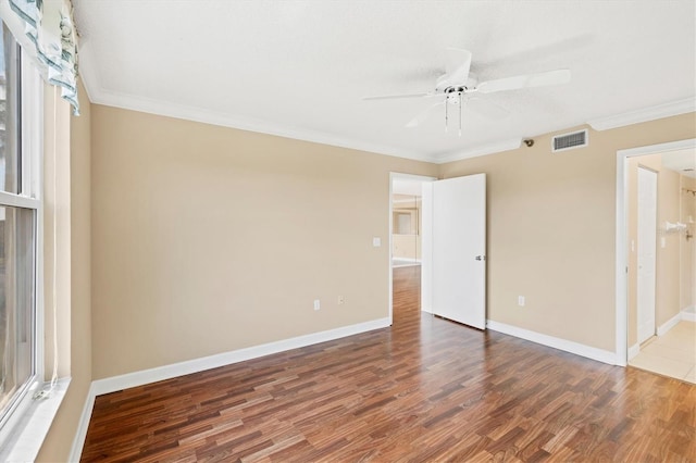 unfurnished bedroom featuring baseboards, visible vents, wood finished floors, and ornamental molding