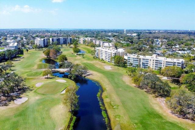 drone / aerial view with golf course view and a water view