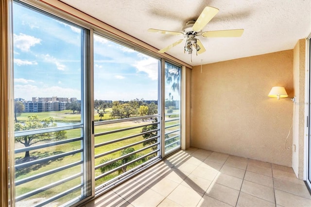 sunroom with ceiling fan and a view of city