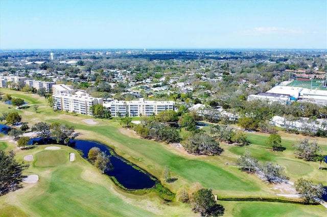 drone / aerial view with view of golf course and a water view