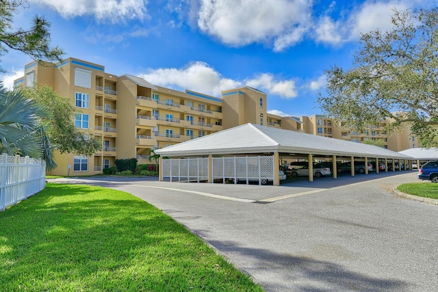 view of property featuring covered parking and fence