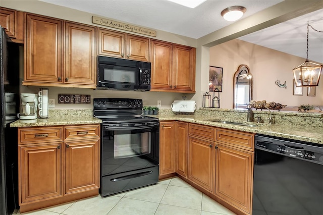 kitchen featuring light tile patterned floors, black appliances, light stone counters, and brown cabinetry