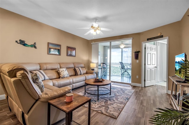 living area featuring wood finished floors, a ceiling fan, and baseboards