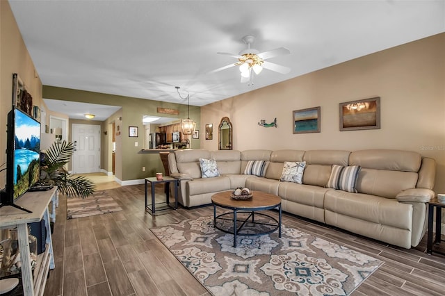 living area featuring ceiling fan, wood finish floors, and baseboards