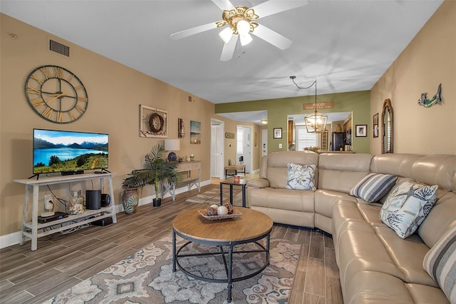 living area featuring baseboards, visible vents, a ceiling fan, and wood tiled floor