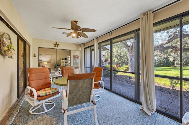 sunroom / solarium with a ceiling fan