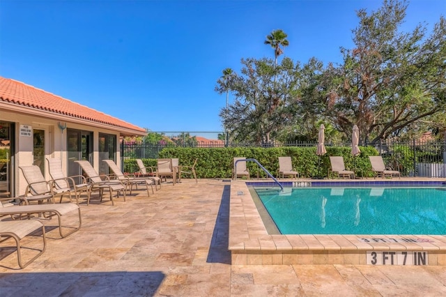 community pool featuring fence and a patio