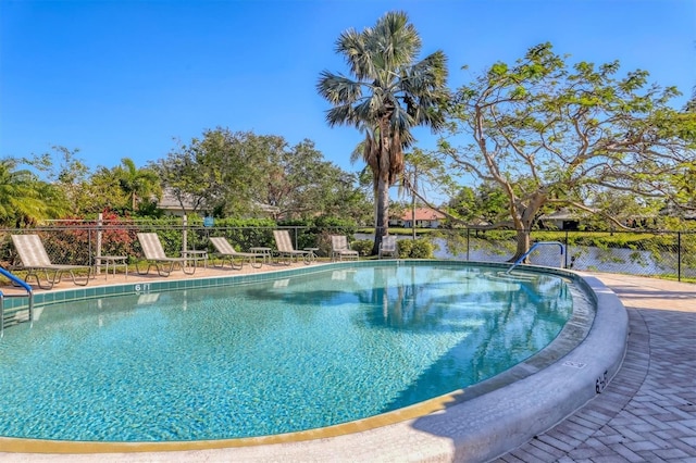 view of swimming pool featuring fence