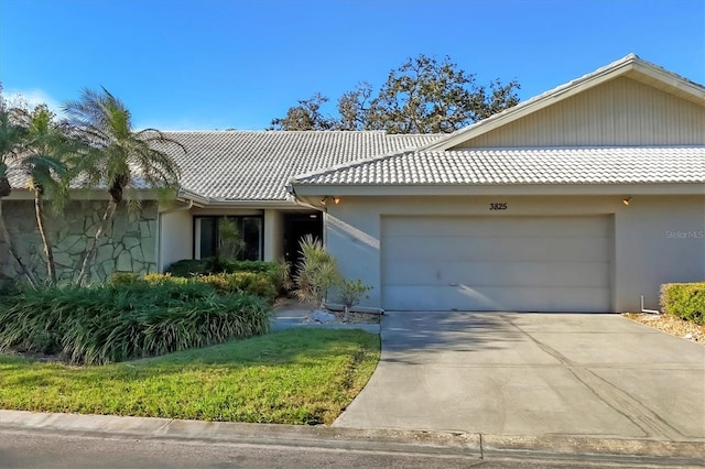 view of front facade featuring a garage, a tiled roof, and stucco siding