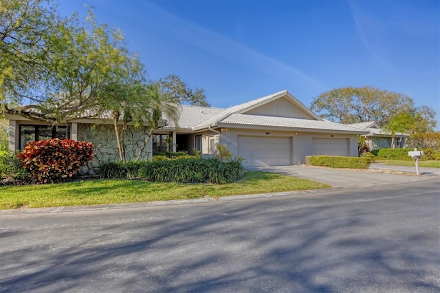 ranch-style home with a garage, a tiled roof, driveway, and stucco siding