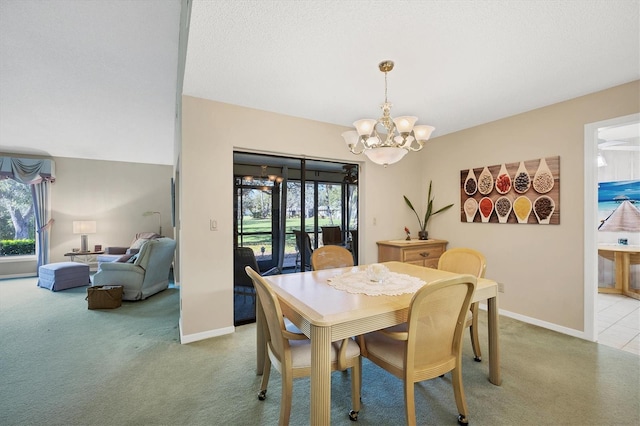 dining space with light carpet, a textured ceiling, baseboards, and a notable chandelier