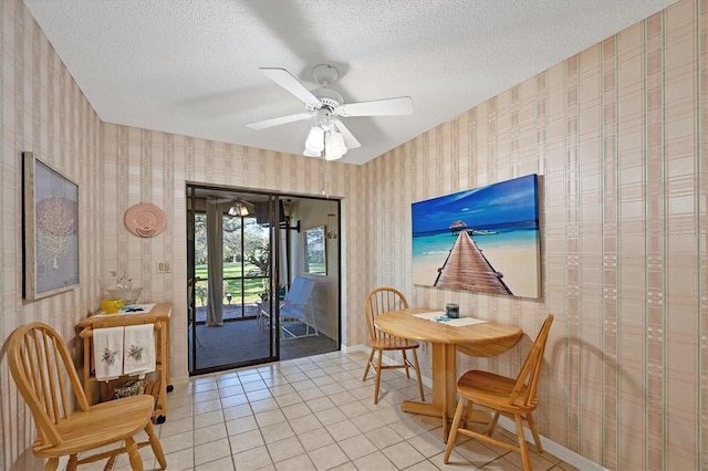 dining room featuring wallpapered walls, baseboards, a textured ceiling, and light tile patterned flooring