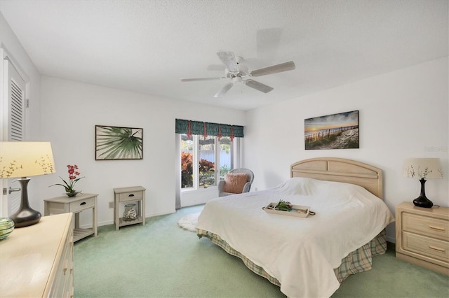 bedroom with light carpet, ceiling fan, and baseboards