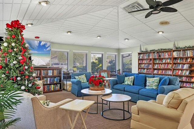 interior space featuring a ceiling fan and wall of books