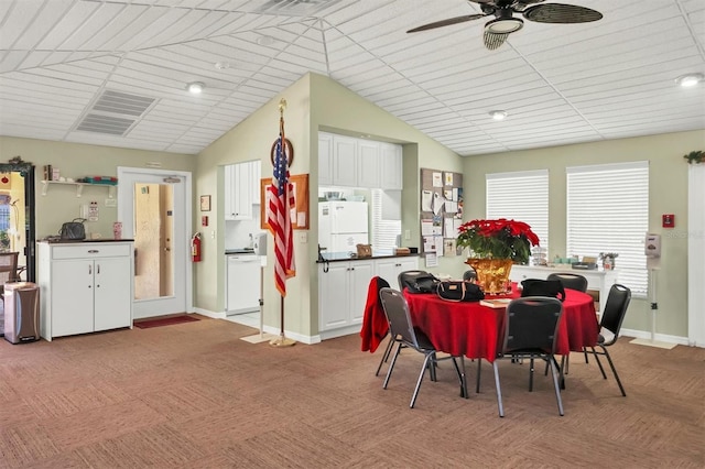 dining area with vaulted ceiling, ceiling fan, light carpet, and baseboards