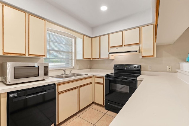 kitchen with black appliances, under cabinet range hood, light countertops, and cream cabinetry