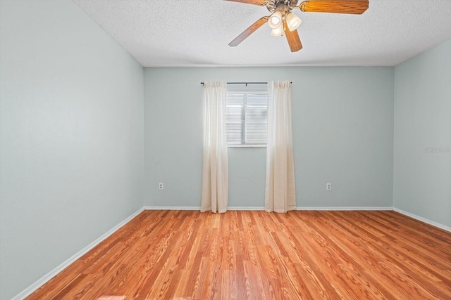 unfurnished room featuring a textured ceiling, light wood-type flooring, and baseboards