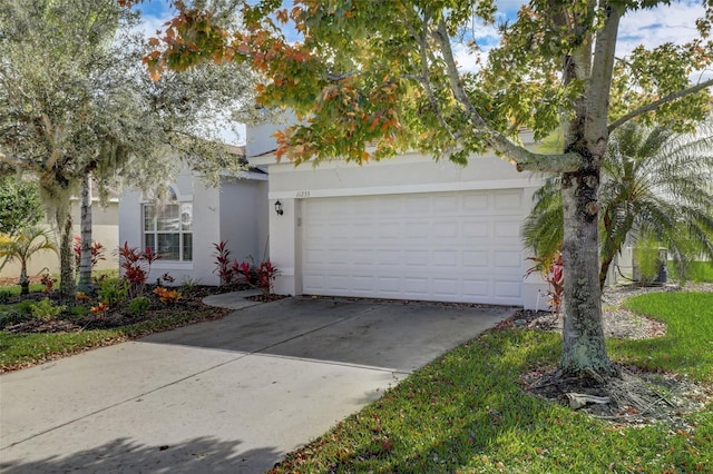 view of front of property featuring an attached garage, concrete driveway, and stucco siding