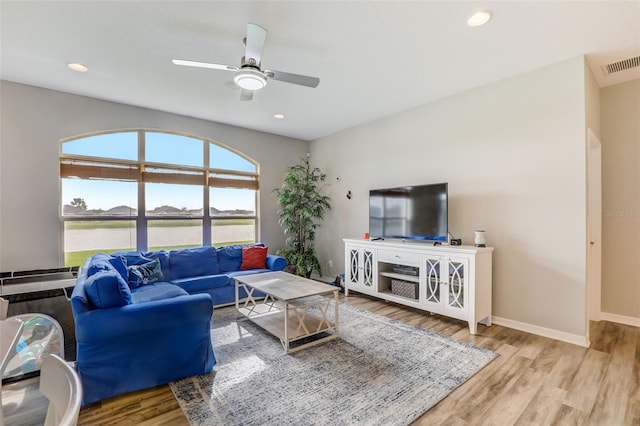 living room with light wood finished floors, baseboards, visible vents, and recessed lighting