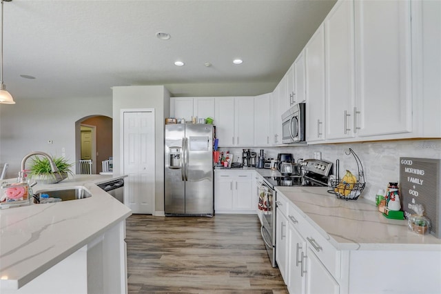 kitchen with white cabinets, appliances with stainless steel finishes, pendant lighting, and a sink