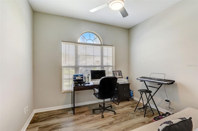 office space with light wood-style floors, baseboards, and a ceiling fan