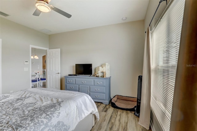 bedroom featuring light wood-style floors, visible vents, and ceiling fan