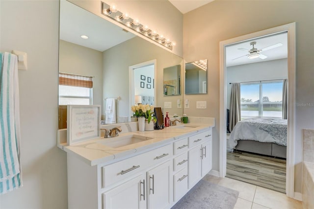 full bathroom featuring double vanity, plenty of natural light, ensuite bath, and a sink