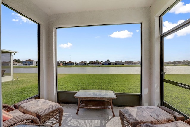 sunroom / solarium with a wealth of natural light, a water view, and a residential view