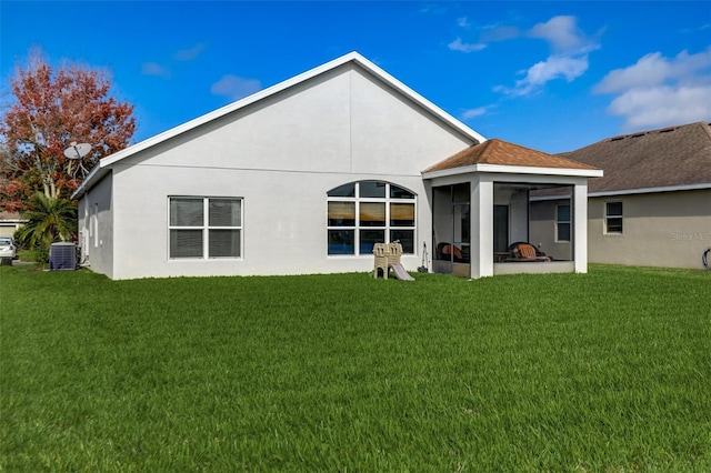 back of property with central AC, a lawn, and stucco siding