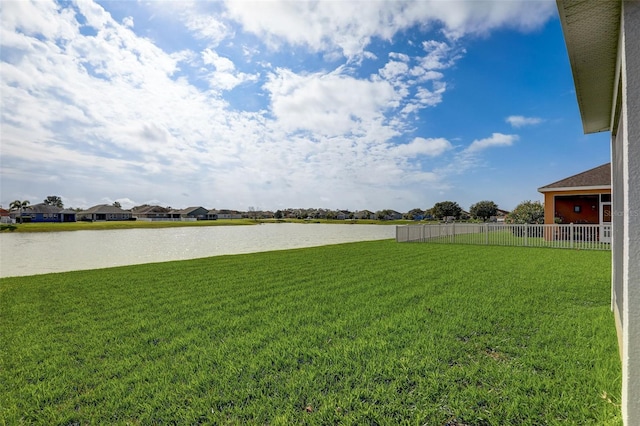 view of yard featuring a water view and fence