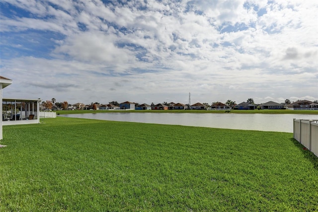 view of yard with a water view, fence, and a residential view