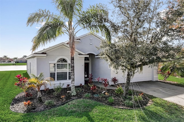 view of front of house featuring driveway, stucco siding, a garage, and a front yard