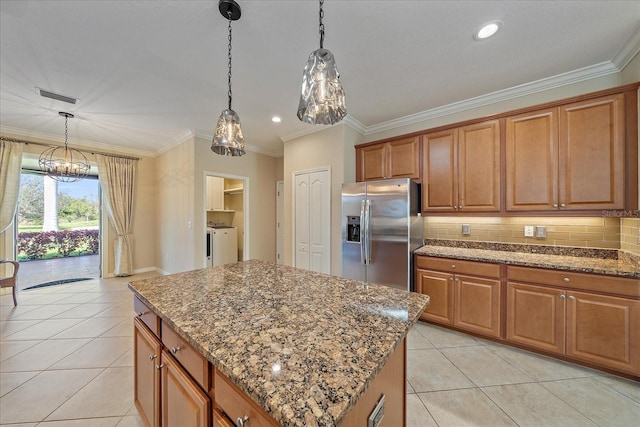 kitchen featuring brown cabinets, stainless steel fridge, and visible vents