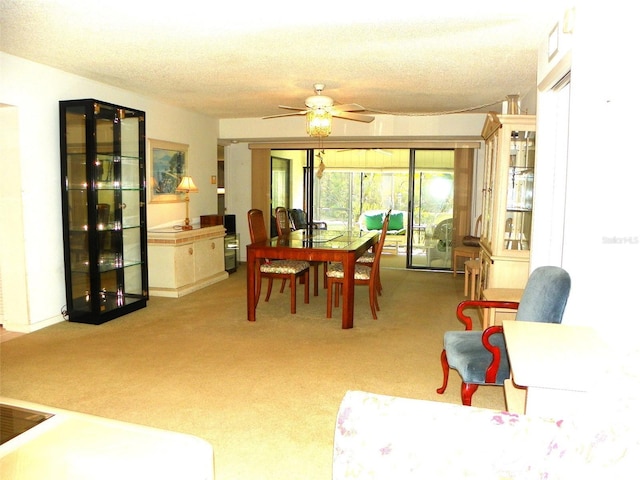 carpeted dining area featuring ceiling fan and a textured ceiling