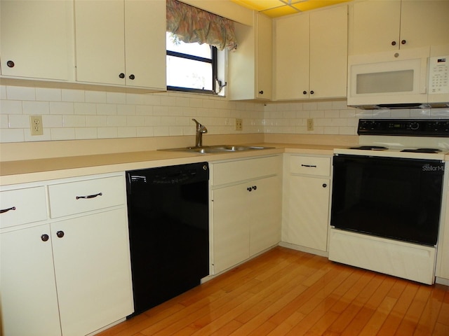 kitchen with tasteful backsplash, white appliances, light countertops, and a sink