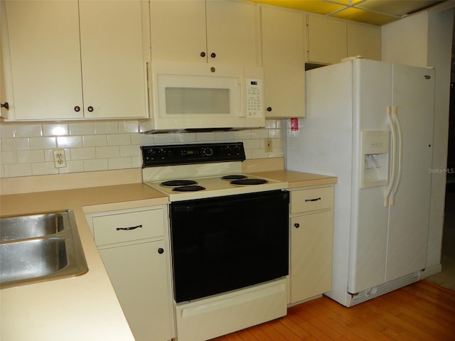 kitchen with white appliances, light countertops, and backsplash