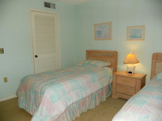 bedroom with light carpet, visible vents, and a closet